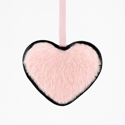 Heart-shaped pink fluffy toy with a black border and pink ribbon on a white background