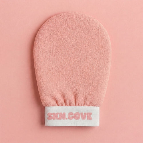 Pink exfoliating glove with 'SKN.COVE' branding on a pink background